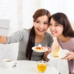 Young women taking photo in cafe