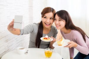 Young women taking photo in cafe